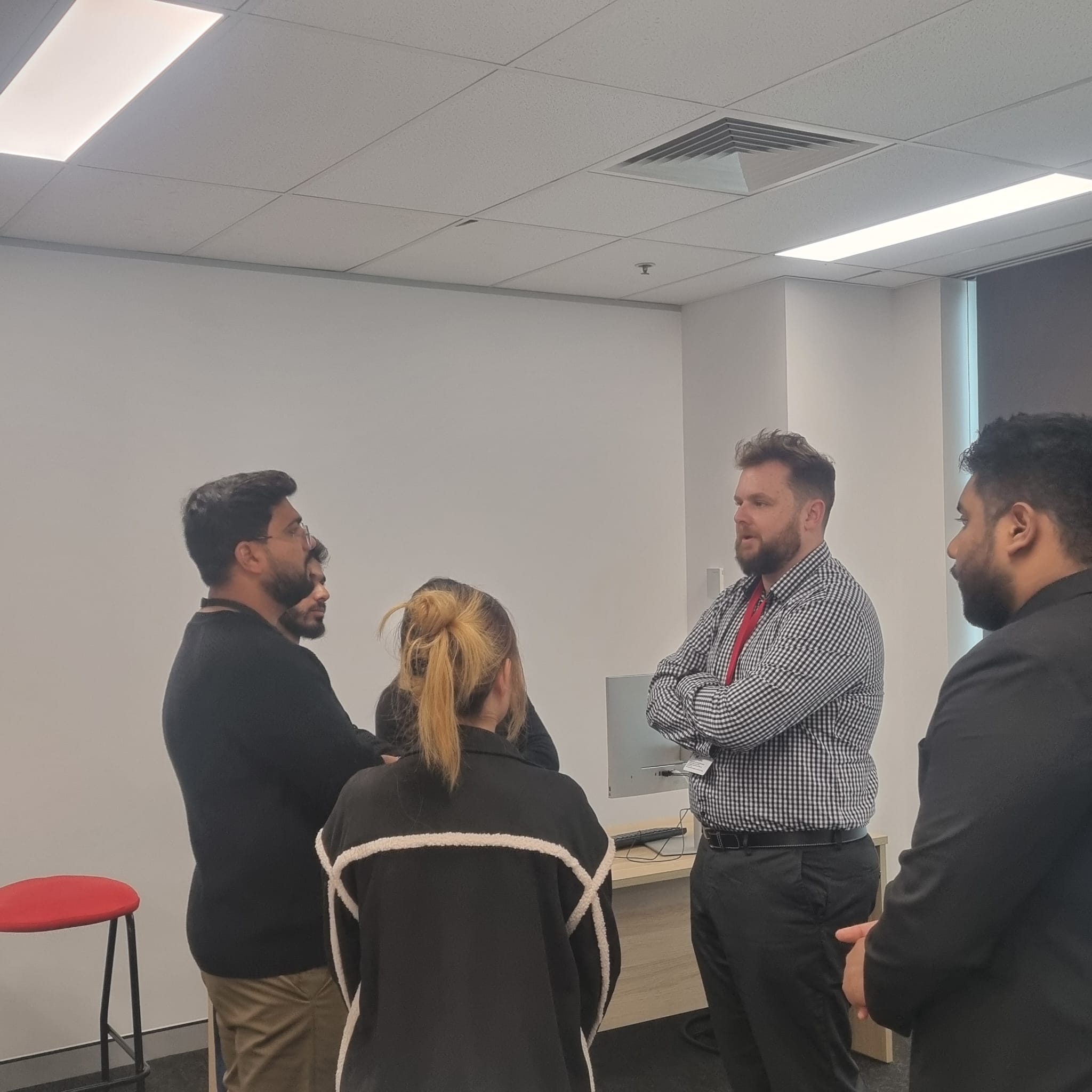 El CEO de Trucell Jason Mead en conversación con estudiantes del campus Sydney de la Universidad de Tasmania después del panel, discutiendo cómo identificar un área personal de especialización temprano en una carrera tech