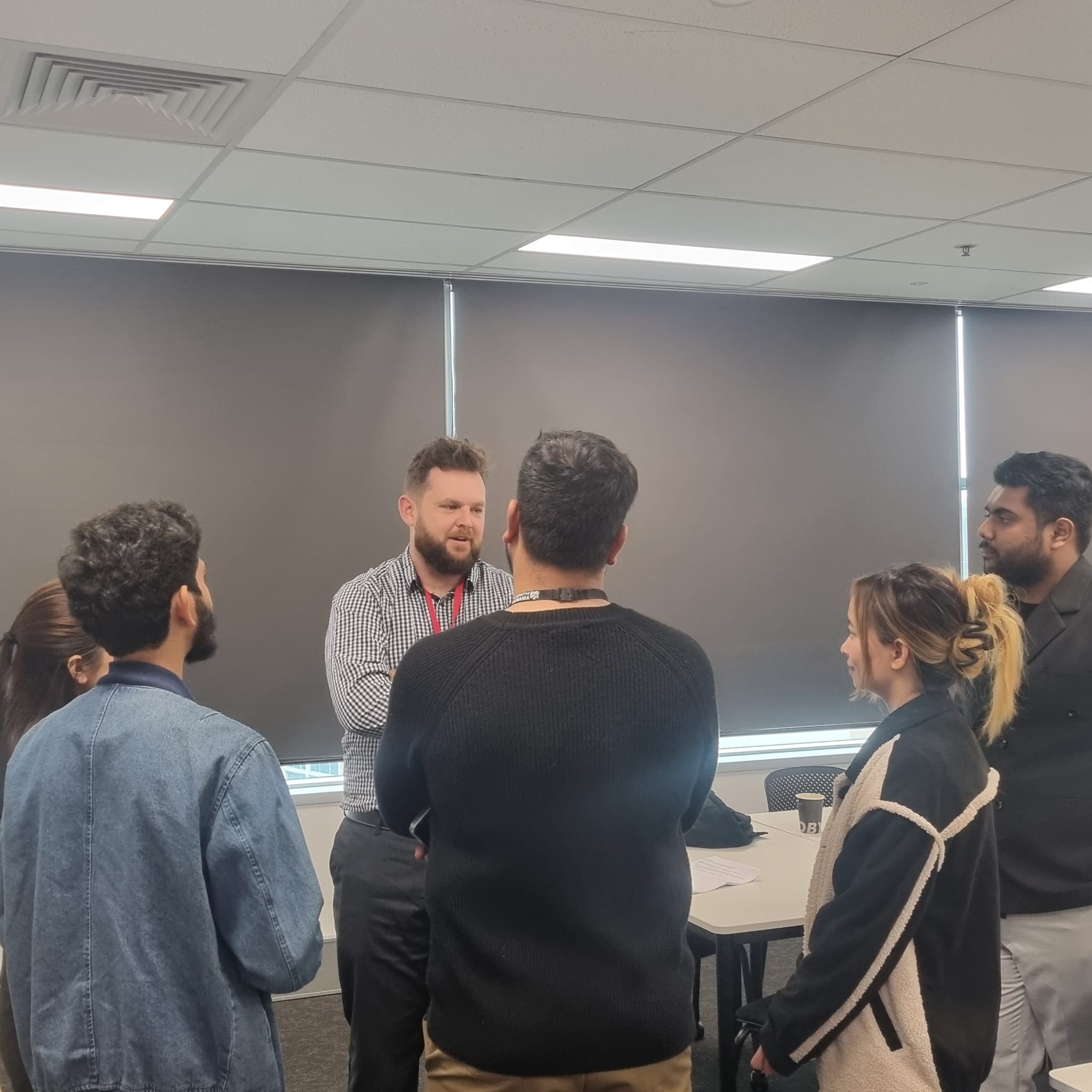 El CEO de Trucell Jason Mead en una discusión de grupo pequeño con estudiantes del campus Sydney de la Universidad de Tasmania después del panel fireside, respondiendo preguntas de seguimiento sobre expectativas de la industria y dirección de inicio de carrera